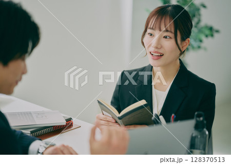 スーツ姿で仕事をする男女 スーツ姿で仕事をする男女 128370513
