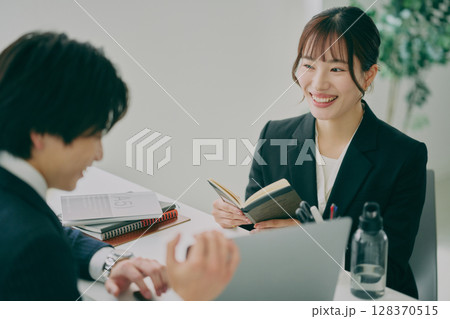 スーツ姿で仕事をする男女 128370515