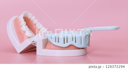 Dental impression tray and teeth model on pink 128372294