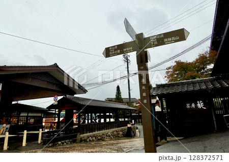 雨の馬籠宿　馬籠宿下入口の交差点に旧中山道の道しるべが立つ風景　岐阜県中津川市馬籠 128372571