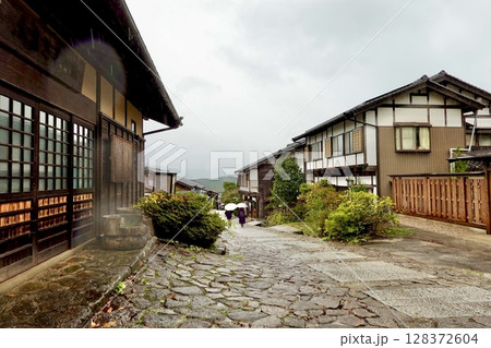 雨の馬籠宿　唄の好きな石臼の前から旧中山道の坂の下を臨む風景　岐阜県中津川市馬籠 128372604