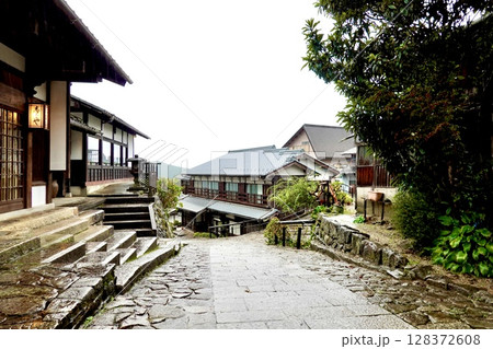 雨の馬籠宿 しまや店舗前から旧中山道の坂の下を臨む風景 岐阜県中津川市馬籠 雨の馬籠宿 しまや店舗前から旧中山道の坂の下を臨む風景 岐阜県中津川市馬籠 128372608