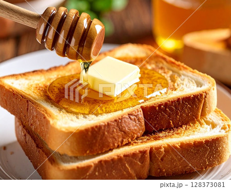 こんがりと焼けたトーストにバターをはちみつをかける 128373081