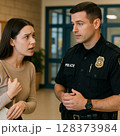 警察に相談する若い女性 128373984