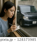 不審車を確認する若い女性 128373985