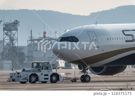 夕暮れの仙台空港 トーイングトラクターと飛行機 宮城県名取市 夕暮れの仙台空港 トーイングトラクターと飛行機 宮城県名取市 128375173