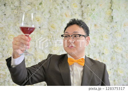 ワイングラスを掲げる男性 128375317
