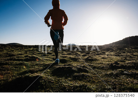 Woman trail runner cross country running to high altitude mountain peak Woman trail runner cross country running to high altitude mountain peak 128375540