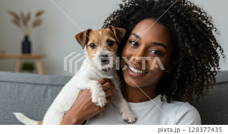 Joyful woman with adorable dog in cozy living room setting 128377435