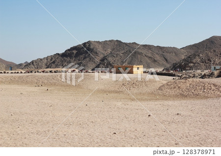Desert landscape with isolated yellow house and rocky mountains. Desert landscape with isolated yellow house and rocky mountains. 128378971
