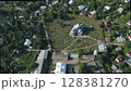 Aerial view of the church and graveyard in the village. Rustic wooden church in the center of the countryside. Rows of burials are located around the temple. 128381270