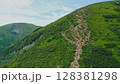 Aerial view of young tourists walking along a mountain trail with backpacks to the top of the mountain. Hiking, climbing, traveling, trekking, backpacking. 128381298