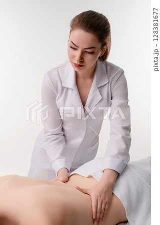 Woman providing soothing massage therapy in a tranquil studio setting 128381677