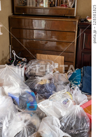 実家仕舞いをしている最中の不用品とゴミだらけの部屋 128381825