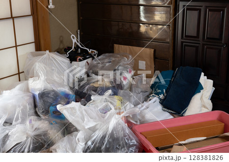 実家仕舞いをしている最中の不用品とゴミだらけの部屋 128381826