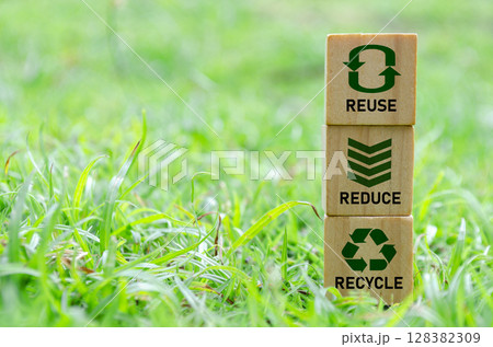 Wooden cube stack with text that reads recycle, reuse and reduce icons on green grass. Environmental concept Wooden cube stack with text that reads recycle, reuse and reduce icons on green grass. Environmental concept 128382309