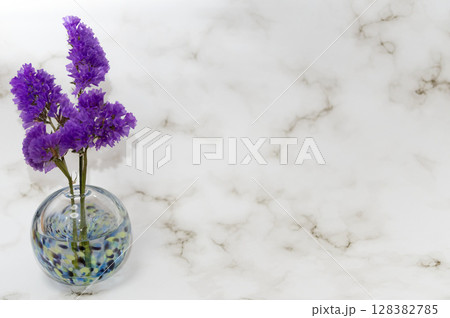 左端配置の寒色のガラス一輪挿しに紫スターチスの花 左端配置の寒色のガラス一輪挿しに紫スターチスの花 128382785