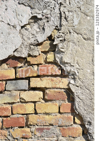 Old wall with crumbling plaster 128382974