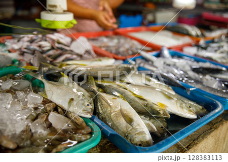 Assorted fresh fish on trays at seafood market display Assorted fresh fish on trays at seafood market display 128383113