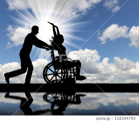 A fun time for a healthy man and a disabled woman in a wheelchair A fun time for a healthy man and a disabled woman in a wheelchair 128384793