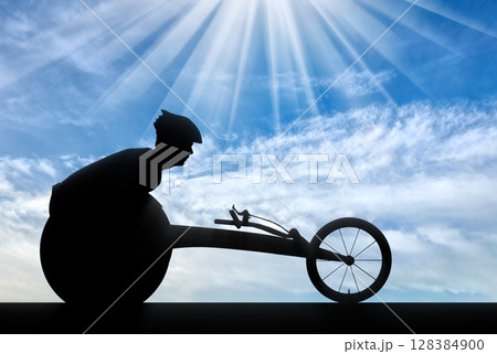 Silhouette of sportsman disabled in a racing wheelchair 128384900