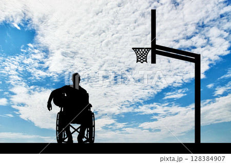 Silhouette of a disabled basketball player in a wheelchair holding the ball in his hand 128384907
