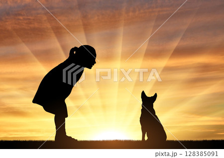 Silhouette of a baby girl and her dog looking at the sunset. 128385091