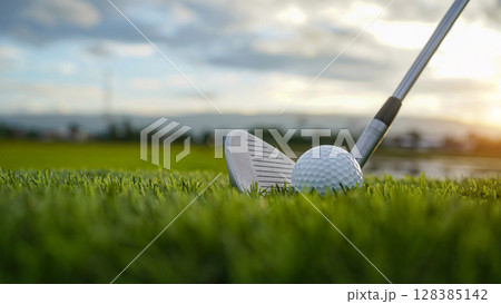Golf clubs and balls on a green lawn in a beautiful golf course with morning sunshine. 128385142