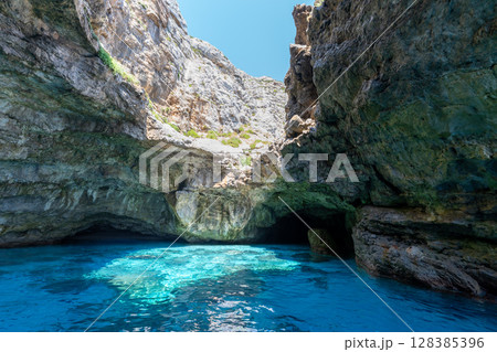 Turquoise water flows into a sea cave on Marettimo island, Italy. Turquoise water flows into a sea cave on Marettimo island, Italy. 128385396
