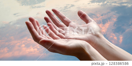 The outstretched hands of a praying man 128386586