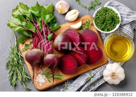 Raw beetroot with garlic, rosemary, thyme and olive oil lying on wooden cutting board 128386912
