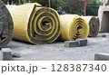 Rolls of thermal insulation material lying on construction site pavement 128387340