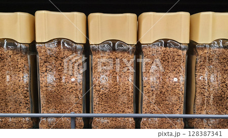 Glass jars of instant coffee filling a supermarket shelf 128387341