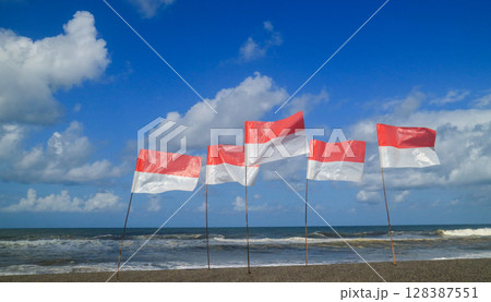 Summer holiday concept. Indonesian flag on the beach with blue sky. 17 August independence day. 128387551
