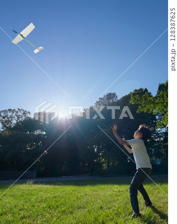 夏の公園で飛行機遊びを楽しむ男児 128387625