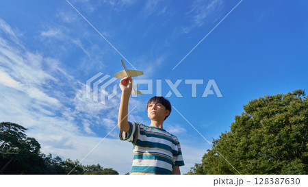 青空のもと模型飛行機を構える男の子 128387630