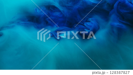Blend flow. Atmospheric smoke. Defocused blue color ink in water fume swirling fog pigment spreading on abstract acrylic background. 128387827