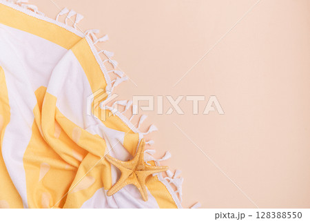 Beach towel and starfish on a light background. Beach towel and starfish on a light background. 128388550