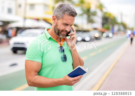 Book the trip. Tourist on summer vacation. Traveler booking summer trip. Summer tour. Traveler enjoy summer trip. Hispanic tourist traveler on city street. Tourist with passport call phone 128388913
