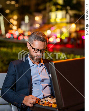Millionaire business man with money. Rich and successful businessman. Millionaire lifestyle. Business success of millionaire. Businessman dealing with money. Successful man count money at night Millionaire business man with money. Rich and successful businessman. Millionaire lifestyle. Business success of millionaire. Businessman dealing with money. Successful man count money at night 128388943