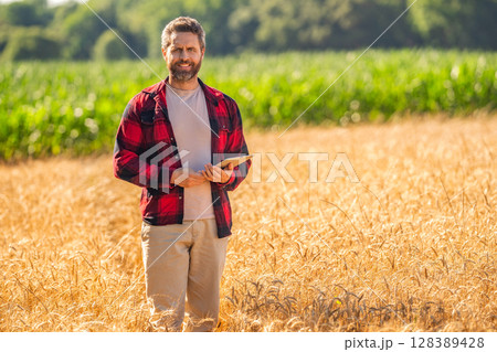 Man agronomist farmer. Crop protection. Agriculture farm. Farm man at wheat field. Crop harvest and farming. Farmer in field. Hispanic man farmer check agriculture field harvest. Lush crop growth 128389428