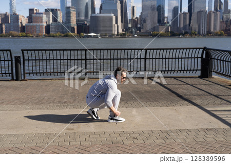 Sportsman tying sneakers. Athletic shoes. Fitness man tie shoelaces outdoor. Fitness man tying lace of sports shoes. Athlete getting ready for workout wearing shoes sitting on floor. Getting ready Sportsman tying sneakers. Athletic shoes. Fitness man tie shoelaces outdoor. Fitness man tying lace of sports shoes. Athlete getting ready for workout wearing shoes sitting on floor. Getting ready 128389596