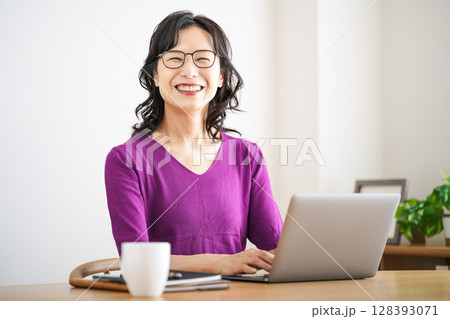 家のリビングでテレワークをする50代のミドル女性 128393071