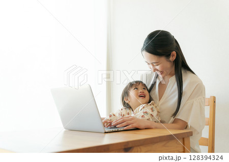 パソコンを見る親子 128394324