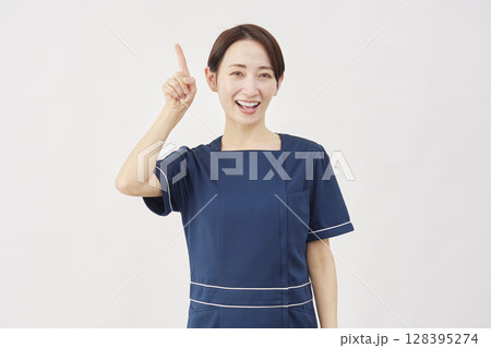 女性 美容看護師 上を指差す 白背景 女性 美容看護師 上を指差す 白背景 128395274