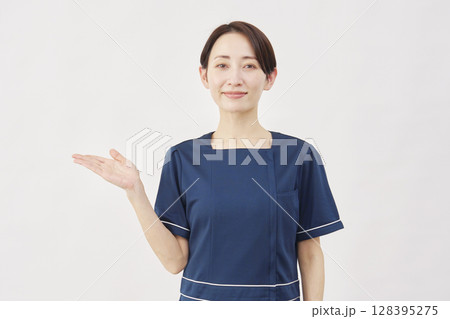 女性 美容看護師 手のひらで左側を指す 白背景 女性 美容看護師 手のひらで左側を指す 白背景 128395275