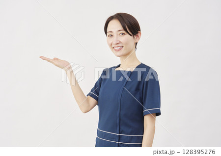 女性 美容看護師 手のひらで左側を指す 白背景 女性 美容看護師 手のひらで左側を指す 白背景 128395276