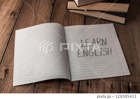 A notebook is open to a page with the word learn english written on it 128395411