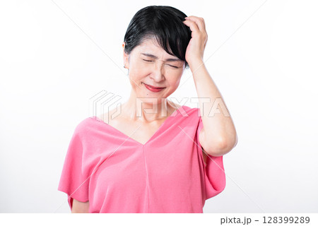 やれやれと頭に手を添え苦笑いするシニア女性 やれやれと頭に手を添え苦笑いするシニア女性 128399289