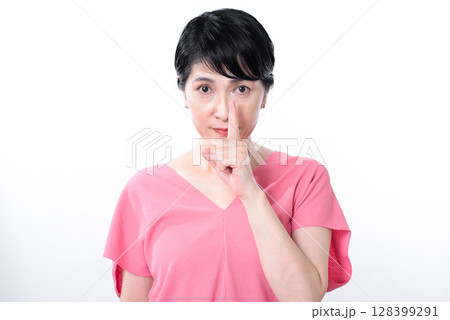 人差し指を口の前で立てて無言で圧をかけるシニア女性 128399291